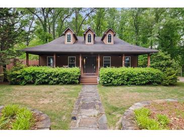 Charming brown home featuring dormer windows and a quaint front porch with meticulously manicured landscaping at 68 Edwin Pl Nw, Atlanta, GA 30318