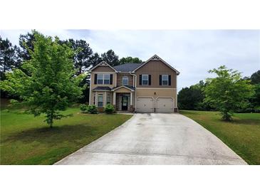 Two-story home with a two-car garage, tidy landscaping, and a long concrete driveway at 6816 Diamond Dr, Rex, GA 30273