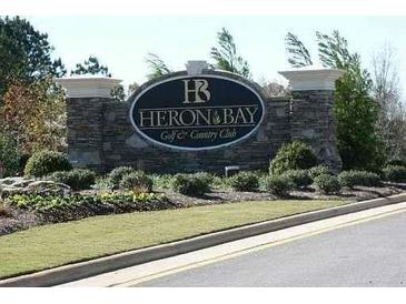 Stone sign for Heron Bay Golf & Country Club with manicured landscaping in a suburban setting at 1213 Dawnview Dr, Locust Grove, GA 30248