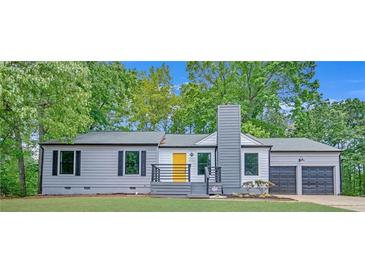 Charming ranch-style home features a freshly painted exterior and updated landscaping with a bright yellow front door at 4336 Southvale Dr, Decatur, GA 30034