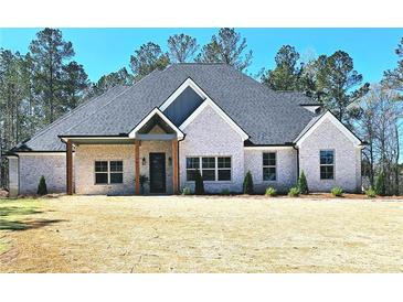 Charming light brick home with dark roof, front porch, and landscaped yard at 261 Arborview Dr, Mcdonough, GA 30252