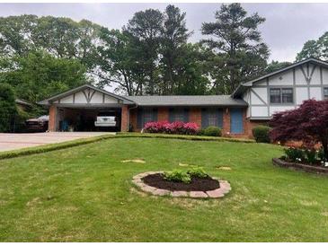 Charming single-Gathering home featuring a well-maintained front yard, covered carport, and brick facade at 3996 Indian Manor Dr, Stone Mountain, GA 30083