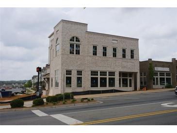 Modern building featuring multiple windows and an intricate brick pattern at 9244 Main Street # 102, Woodstock, GA 30188