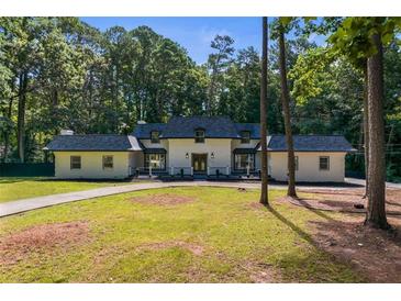 Charming single-Gathering home featuring a manicured lawn and surrounded by mature trees, offering a serene setting at 2023 Stoneleigh Dr, Stone Mountain, GA 30087