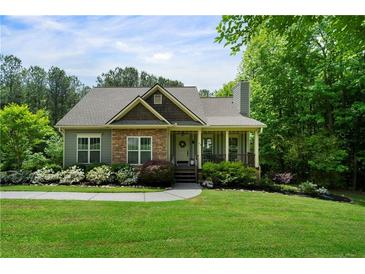 Charming home with stone accents, covered porch, and beautifully landscaped front yard and walkway at 33 Kay Ne Rd, White, GA 30184
