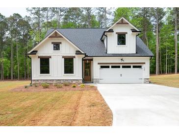 Charming new construction home featuring a white facade, a two-car garage, and a meticulously manicured lawn at 130 Doris Path, Dallas, GA 30157