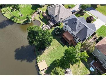 Stunning aerial view of a backyard and lake with a well-maintained lawn, deck, and mature trees at 2436 Camden Lake Nw Vw, Acworth, GA 30101