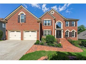 Two-story brick home with a manicured lawn, two-car garage, and brick stairs leading to the front door at 2436 Camden Lake Nw Vw, Acworth, GA 30101