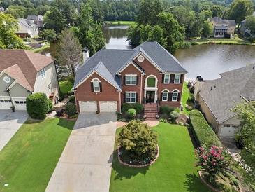 Beautiful two-story brick home with a well-manicured lawn and a view of the lake at 2436 Camden Lake Nw Vw, Acworth, GA 30101