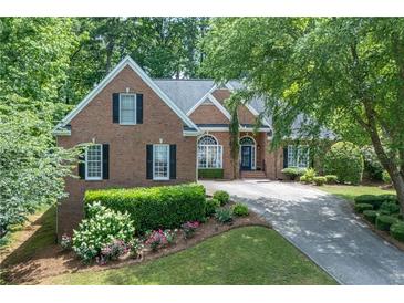 Charming brick home with manicured landscaping, shutters, and a welcoming blue front door at 4825 Brighton Lake Dr, Cumming, GA 30040