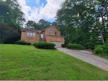 Two story brick home with well maintained lawn and attached two car garage at 3723 Raiders Ridge Dr, Lithonia, GA 30038