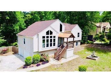 Charming home featuring large windows, a covered entry, landscaped yard, and a decorative fountain at 3748 Woodrose Ct, Snellville, GA 30039