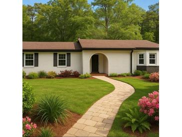 Charming single-story home featuring a well-manicured lawn, brick walkway, and beautiful landscaping at 2744 Preston Dr, Decatur, GA 30034