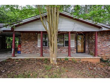 Charming brick home with a covered front porch and mature trees, creating a welcoming entry at 3082 Corbin Ave, Decatur, GA 30034