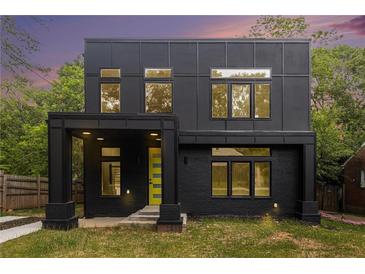 Modern two-story home features a black exterior, a bright yellow door, and many windows at 2402 Lynn Iris Dr, Decatur, GA 30032