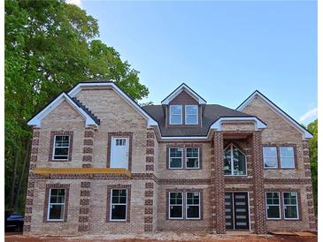 Stunning two-story brick home boasting grand entrance, dormer window, and expansive front windows at 1360 Dickens Nw Rd, Lilburn, GA 30047