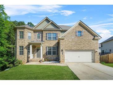 Charming brick two-story home featuring a well-manicured lawn and a two-car garage at 15 Manas Ct, Covington, GA 30016