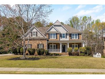 Traditional two-story brick home with a well-manicured lawn, covered porch, and inviting curb appeal at 2123 Indian Ivey Ln, Dacula, GA 30019