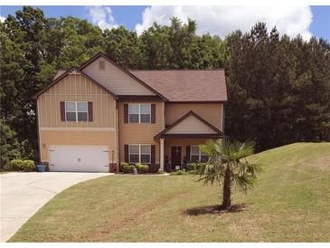Charming two-story home featuring a well-manicured lawn and a driveway leading to an attached garage at 504 Liverpool Dr, Mcdonough, GA 30252