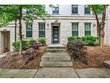 Charming brick townhome with well-manicured landscaping and inviting entryway with decorative front door at 247 Franklin Rd, Atlanta, GA 30342