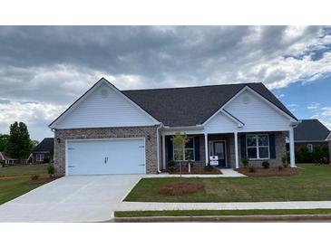 Charming one-story home with brick and white siding, complemented by a well-manicured front lawn at 911 Park Place St, Social Circle, GA 30025