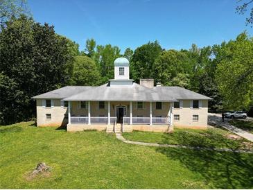 Charming home with a spacious front yard, covered porch, and architectural details at 11433 Panhandle Rd, Hampton, GA 30228