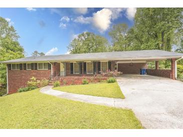 Charming brick home with well-manicured front yard and a covered carport at 3560 Emily Way, Atlanta, GA 30349