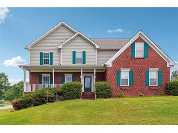 Charming two-story home with a well-manicured lawn and welcoming front porch at 3715 Frankie Wade Ln, Loganville, GA 30052