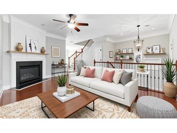 Bright living room with a cozy fireplace, modern ceiling fan, and beautiful staircase at 2313 Millhaven St, Smyrna, GA 30080