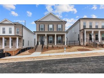Charming two-story home featuring a covered porch, gray brick facade, and landscaped front yard at 173 Basil St, Cumming, GA 30040