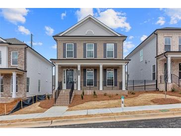 Charming two-story brick home with a welcoming front porch and well-manicured yard in a vibrant community at 173 Basil St, Cumming, GA 30040