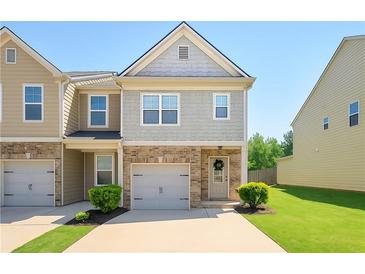 Charming two-story townhome features a brick facade, gray siding, manicured lawn and attached garage at 4925 Longview Walk, Decatur, GA 30035
