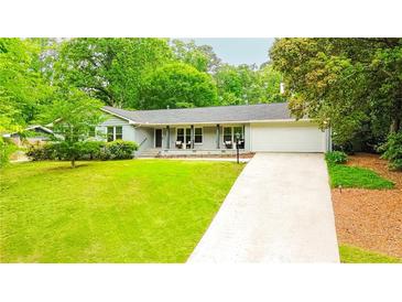 Charming single-story home featuring a well-manicured lawn and an attached two-car garage at 1662 Rainier Falls Ne Dr, Atlanta, GA 30329