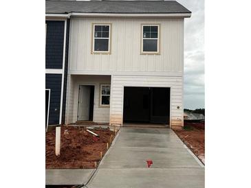 New construction home featuring a two-car garage and concrete driveway at 9462 Pinecrest Path # 319, Jonesboro, GA 30238