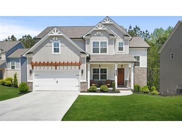 Charming two-story home with a well-manicured lawn, a pergola over the garage, and a welcoming front porch at 410 Crestbrook Ln, Dallas, GA 30157