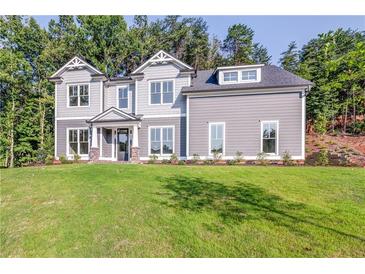 Charming two-story home featuring a manicured front lawn, gray siding, and well-crafted architectural details at 3745 Reserve Overlook (#30) Way, Cumming, GA 30041