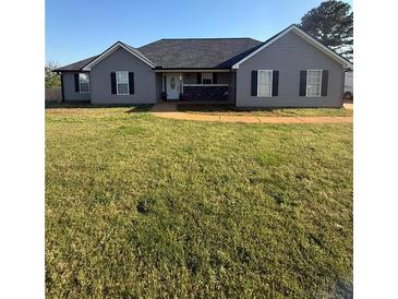 Charming one-story home with a well-maintained lawn, classic design, and a welcoming entrance with a covered porch at 237 Ferguson Ave, Locust Grove, GA 30248