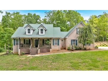 Charming brick home features a covered front porch, a metal roof, and a well-manicured front lawn at 4332 Brushy Mountain Rd, Rockmart, GA 30153