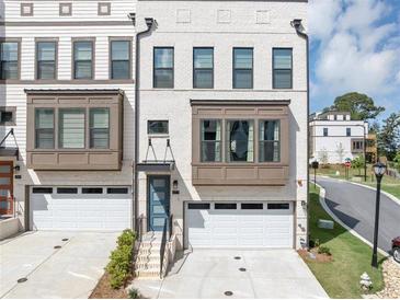Modern townhome with a white brick facade, bay windows, and a one car garage at 2171 Burnside Dr Nw, Atlanta, GA 30318
