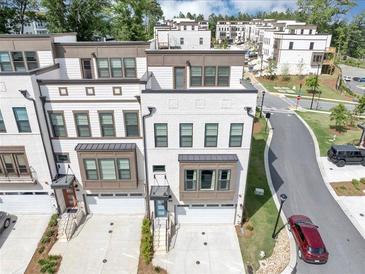 Modern townhomes featuring white brick, bay windows, and attached garages in a well-maintained community at 2171 Burnside Dr Nw, Atlanta, GA 30318