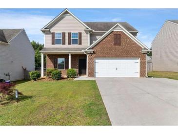 Charming two-story home with brick and vinyl siding, featuring a two-car garage and well-manicured lawn at 2267 Clapton Ct, Jonesboro, GA 30236