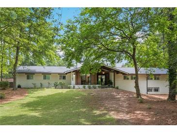 Charming single-story home with a lush lawn, mature trees, and a welcoming front facade at 5785 Timberlane Ter, Sandy Springs, GA 30328