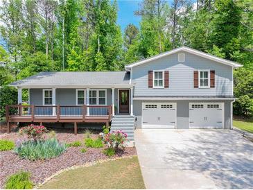 Charming home featuring a welcoming front porch, two-car garage, and beautifully landscaped front yard at 4124 Dunnington Dr, Marietta, GA 30062