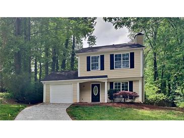 Charming two-story home with a well-maintained lawn and a paved driveway leading to a single-car garage at 829 Longfellow Ct, Stone Mountain, GA 30088