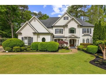 Beautiful two-story home features a lush green lawn with manicured landscaping and a charming, symmetrical facade at 3938 Hillsman Ln, Marietta, GA 30062