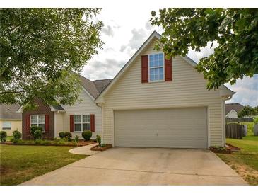 Charming home featuring a two-car garage, red shutters, and a well-maintained front lawn at 4005 Brushymill Ct, Loganville, GA 30052