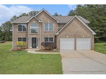 Charming two-story brick home with a well-manicured lawn and an attached two-car garage at 1024 Odelle Cir, Mcdonough, GA 30253