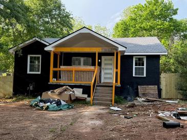 Shows the exterior of this black house with a yellow porch being rebuilt at 388 Sargent Se Dr, Atlanta, GA 30315