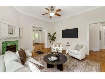 Bright living room with hardwood floors, ceiling fan, fireplace, and comfortable seating at 120 Warren Ne St, Atlanta, GA 30317