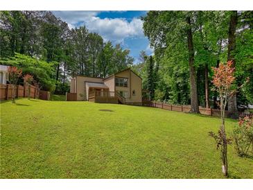 Expansive backyard with lush lawn and a charming home with a wooden deck at 2926 Swarthmore Dr, Lawrenceville, GA 30044